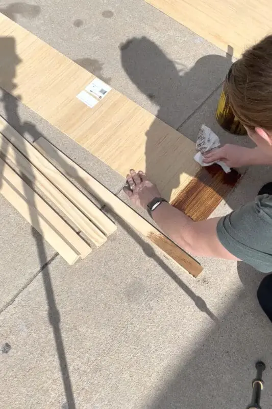 Applying stain to a board.